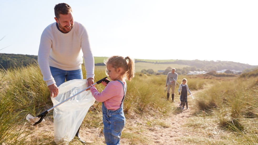 Man and child cleaning a beach